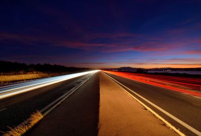 Empty road against sky during sunset