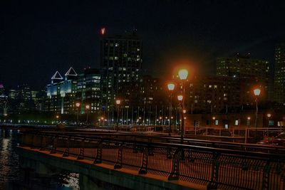 Illuminated railroad station platform against sky at night