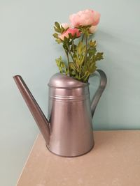 Close-up of flower vase on table against wall