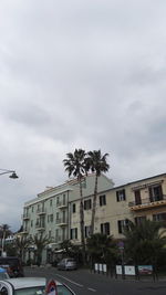 Cars on road against sky in city