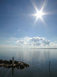 Sun shining through clouds over sea