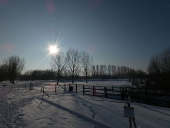 Scenic view of snow covered field against sky during winter