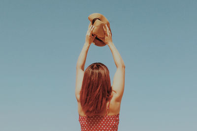 Rear view of woman standing against clear sky