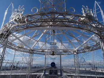 Low angle view of ferris wheel against blue sky