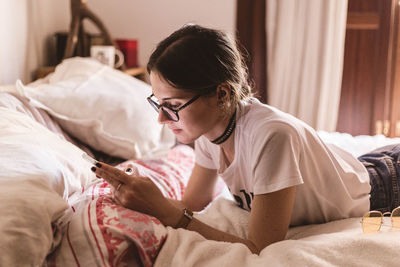 Woman lying on bed at home