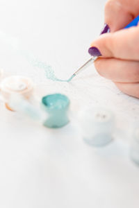 Cropped hand of woman holding dentures