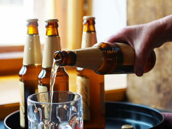 Close-up of hand pouring wine in glass