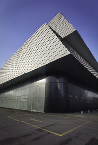 Low angle view of modern building against clear blue sky