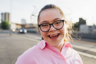 Happy teenage girl with down syndrome wearing eyeglasses