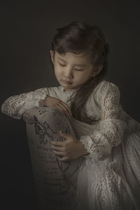 Close-up of girl against black background