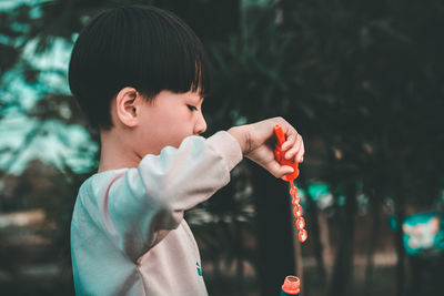 Portrait of boy holding ice cream outdoors