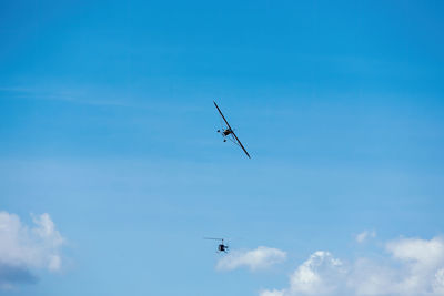 Low angle view of airplane flying against blue sky