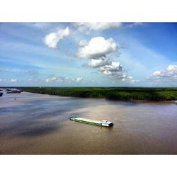 Boats in sea against cloudy sky