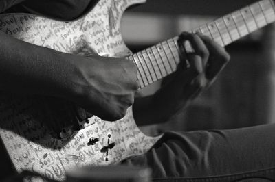 Midsection of man playing guitar