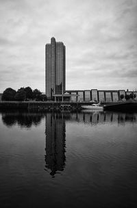 Reflection of building in lake against sky