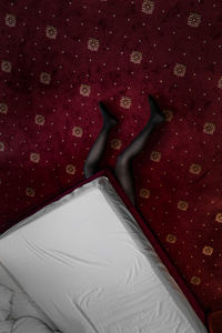 Low section of woman lying below bed