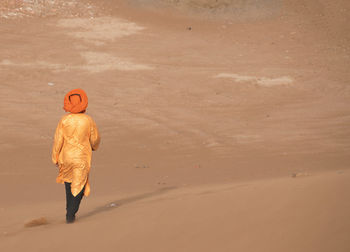 Rear view of man walking on beach