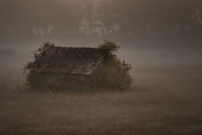 Abandoned house on field against sky