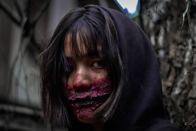 Close-up portrait of young woman with spooky face paint during halloween