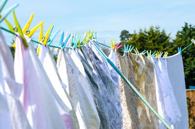 Close-up of clothes drying on clothesline against sky