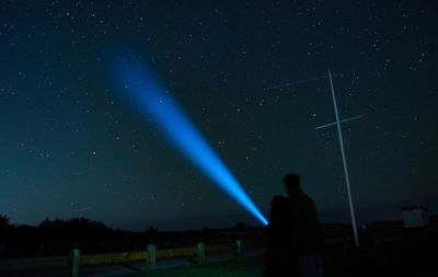 Low angle view of person against sky at night