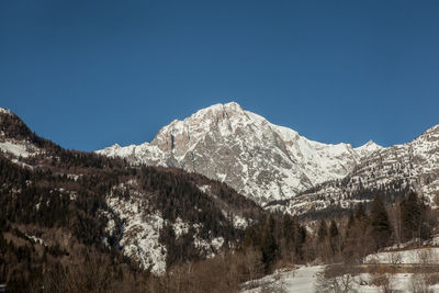 Scenic view of snow covered mountains against clear sky