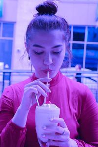 Close-up portrait of a young woman drinking drink