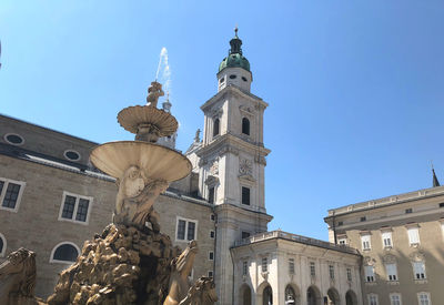 Low angle view of fountain against historic building