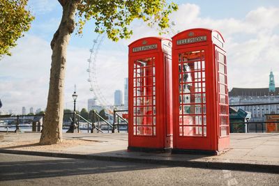 London telephone boxes on an empty street by the river thames