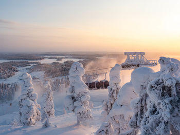 Scenic view of snow covered landscape against sky during sunset