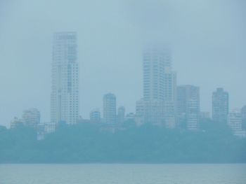 Buildings in city against cloudy sky