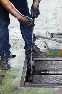 Low section of man working on metal