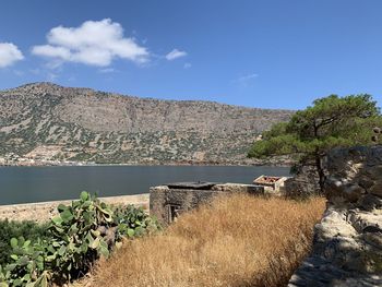 Scenic view of lake by mountain against sky