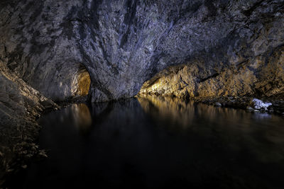 Scenic view of lake by cave