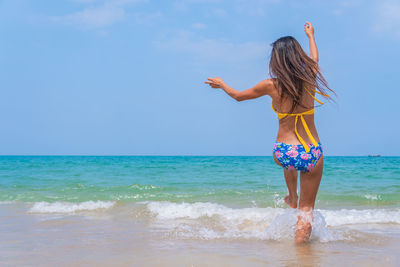 Rear view of woman wearing bikini at beach
