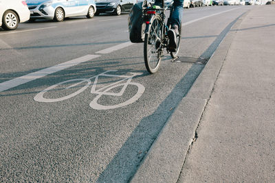 Low section of man riding bicycle on road