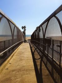 Footbridge over river against clear sky