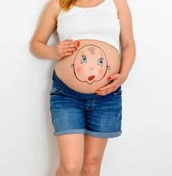Midsection of woman standing against white background