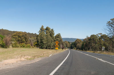 Australian outback road with attention to wildlife signs with kangaroo and wombat.