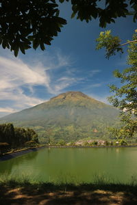 Scenic view of lake by mountains against sky