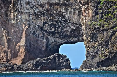 Rock formations by sea against sky