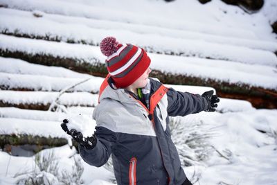 Boy playing with snow at field