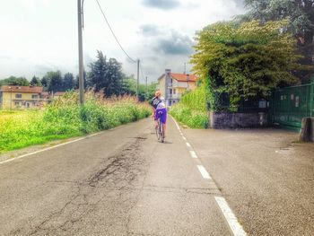 Rear view of people walking on road