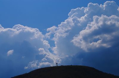 Low angle view of silhouette mountain against blue sky