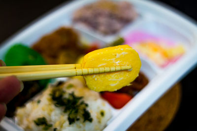 Close-up of hand holding food in bowl