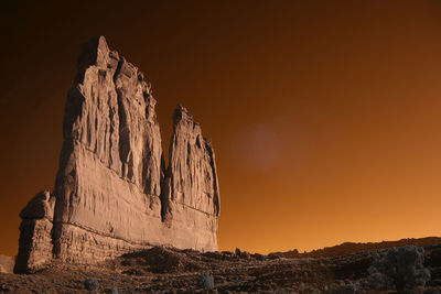 Rock formation on land against sky during sunset