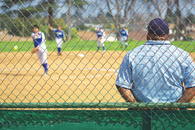 Full length of child playing with chainlink fence