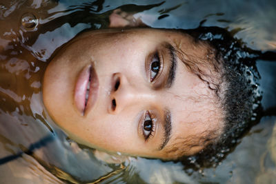 Close-up portrait of young woman in water