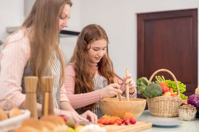 Mother and girl having food at home