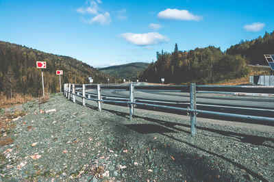 Road amidst field against sky